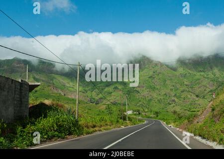 Asphalt road leading in green mountain with cloud on cape verde island Stock Photo
