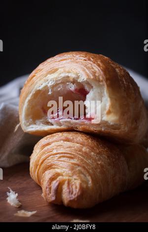 Closeup of croissant with jam on a wooden background Stock Photo