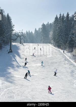 Ski resort winter season mountain slope with people sport skiing and snowboarding day time sunny wea Stock Photo