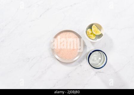 Flat lay. Garnishing edged of the glass with salt for frozen watermelon margarita. Stock Photo