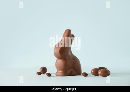 Happy Easter greeting card with chocolate rabbit figure and eggs on blue background. Stock Photo