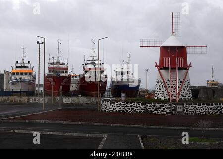 Tuna fishing vessels and wind mill in Madalena habour, Pico Island, Azores Stock Photo