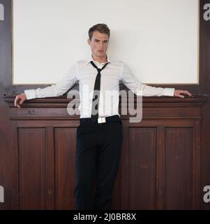 He has a relaxed attitude. Portrait of a handsome young man in a suit with copyspace behind him. Stock Photo