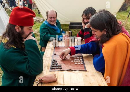 England, East Sussex, Battle, The Annual Battle of Hastings 1066 Re-enactment Festival, Participants Dressed in Medieval Costume Playing Backgammon Stock Photo