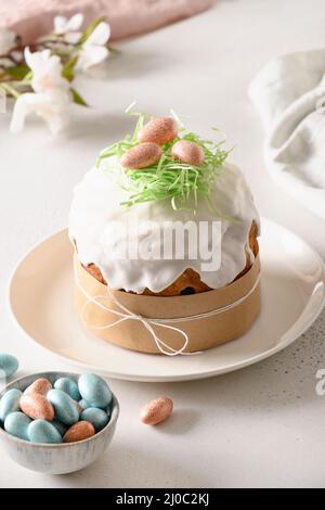 Easter festive cake and colorful eggs on white table. Close up. Vertical. Stock Photo