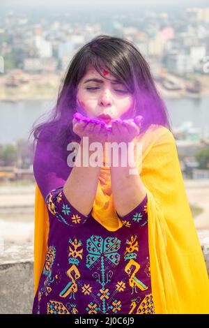 March 18, 2022, Narayanganj, Dhaka, Bangladesh: Girls celebrate the ''Holi'' festival by adorning themselves with colors and smearing each other with colored powders in Narayanganj, Bangladesh. ''Holi'', known as the ''festival of colors'', is celebrated at the end of the winter season on the last full moon day of the lunar month. The festival celebrates the eternal and divine love of Radha and Krishna. It also signifies the victory of good over evil.The Holi festival is celebrated to mark the onset of spring, with people from all walks of life coming out on the streets and applying colored po Stock Photo