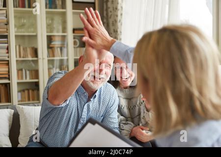 Seniors at the High Five look forward to a pension consultation or the conclusion of a contract Stock Photo