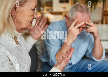 Senior couple having an argument with frustrated man and aggressive senior woman at home Stock Photo