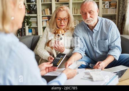 Senior couple gets help from the tax consultant with the tax return and sorts receipts Stock Photo
