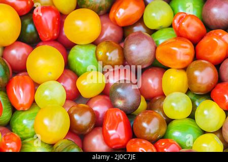Fresh cherry tomatoes in different colors on display in a grocery market Stock Photo