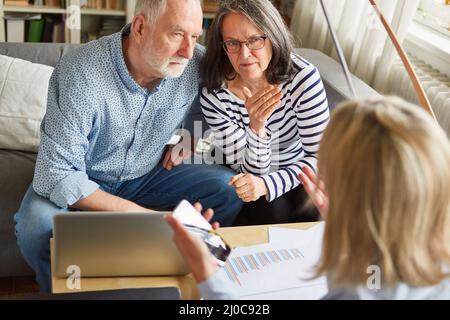 Tax advisor or financial advisor explains senior couple the offer to finance care Stock Photo