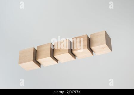 Business concept - Abstract geometric real floating wooden cube on grey background and it's not 3D render. Stock Photo