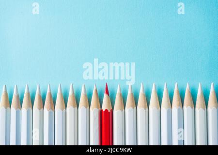 Business concept - lot of white pencils and color pencil on blue paper background. It's symbol of fight Stock Photo
