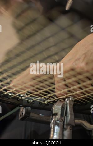 Racket stringing. Detail of tennis racket in the stringing machine Stock Photo