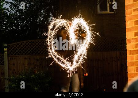 Large heart drawn out with a sparkler Stock Photo