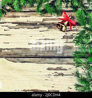New Year's background. Fluffy branches of a Christmas tree and a Christmas bell. Stock Photo