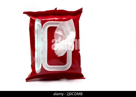 Close up of red plastic package for cosmetics products with opened lid and wet wipes filled and one to pull out sticking out on white background body Stock Photo