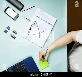Young freelancer working at home at a table using a laptop Stock Photo