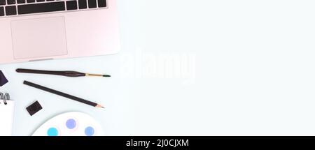 Banner with tools for painting on a blue background. Laptop, watercolor, paintbrush and stationery. Stock Photo