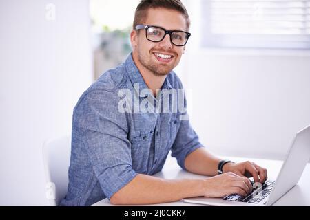 Modern business Fast-paced, innovative and online. A young creative businessman using his laptop. Stock Photo