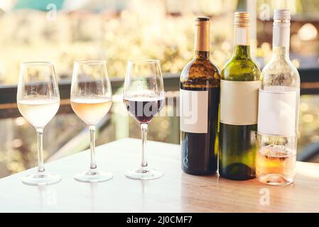 The only way to do wine tasting. Cropped shot of various wines lined up on a table for an outdoors wine tasting. Stock Photo