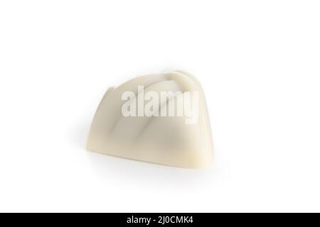 Isolated white chocolate praline or chocolate bonbon. Closeup of one small non uniform chocolate truffle piece coated with white chocolate. Selective Stock Photo