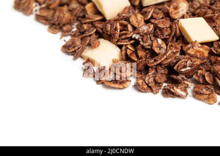 Granola with white chocolate pieces. Large amount of chocolate covered baked rolled oats clusters, randomly placed. Cereal background or healthy snack Stock Photo