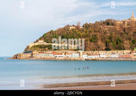 Paddle boarders in Bahia de La Concha, San Sebastian with views of the old town and medieval castle on the hill Stock Photo