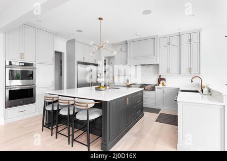 https://l450v.alamy.com/450v/2j0d16x/a-luxurious-kitchen-with-a-large-island-gold-faucet-and-sputnik-chandelier-stainless-steel-appliances-and-white-marble-countertops-2j0d16x.jpg