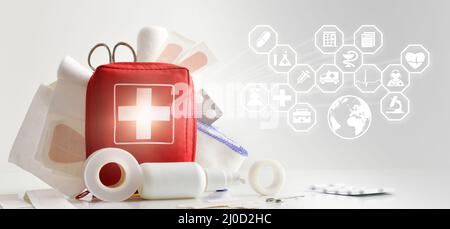 international aid healthcare medicine with first aid kit on table full of basic equipment and icons related to medicine. Horizontal composition. Front Stock Photo