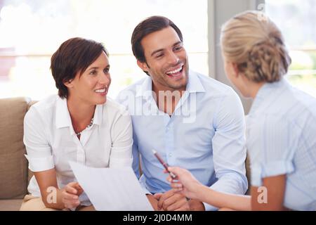 Making smart investment choices. Shot of a financial advisor explaining documents to a couple. Stock Photo