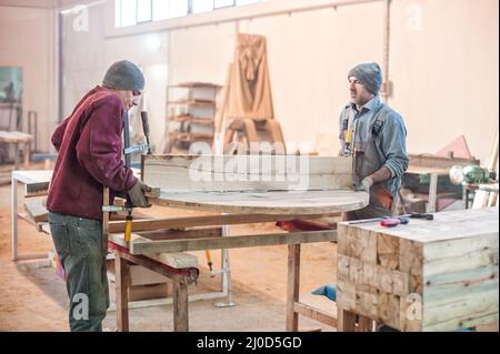 Man doing woodwork in carpentry. Carpenter work on wood plank in workshop Stock Photo