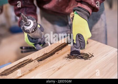 Man doing woodwork in carpentry. Carpenter work on wood plank in workshop Stock Photo