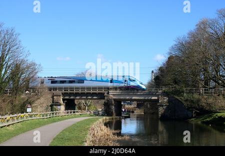 TransPennne Express  Nova 1 bi-mode multiple-unit train, unit 802211, on West Coast Main Line crossing bridge over Lancaster Canal on 18th March 2022 Stock Photo