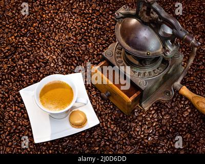 Fresh cup of coffee, roasted beans and antique grinder Stock Photo
