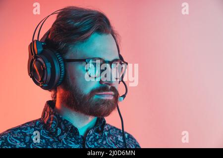 middle aged man using headphones with microphone while playing a video game or attending a business call. High quality photo Stock Photo
