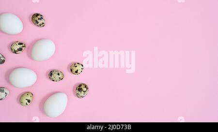 Easter arrangement on left side of pastel pink background with copy space. White and quail natural eggs. Spring holidays concept Stock Photo