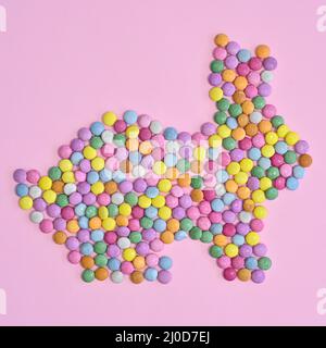 Creative rabbit bunny made with colorful candies on pastel pink background. Flat lay Easter concept Stock Photo