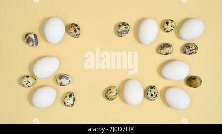 Creative Easter frame with white and quail eggs on pastel beige background. Flat lay minimal copy space Stock Photo