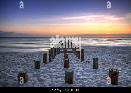 Ruins of the old Naples Pier at sunset on the ocean Stock Photo