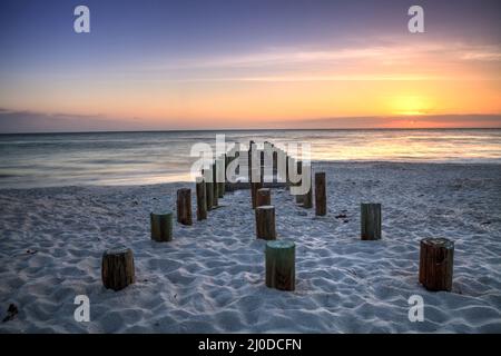 Ruins of the old Naples Pier at sunset on the ocean Stock Photo