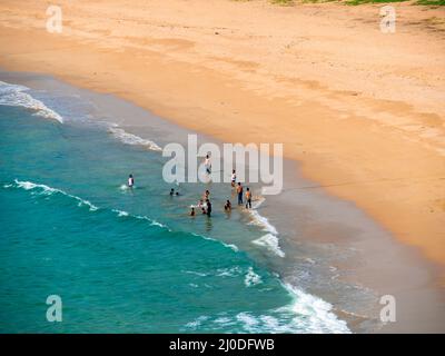 Sindhudurg, India - December  21, 2021 : Unidentified Indian guys playing with a ball and enjoying at neat and clean Devgadh beach water. Stock Photo