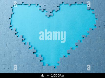 Heart shaped on blue background. Jigsaw puzzle pieces. Space for text. Copy space Stock Photo
