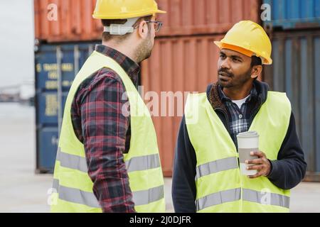 Multiethnic industrial operators working inside international containers port terminal - Freight logistics operations - Focus on Indian worker man Stock Photo