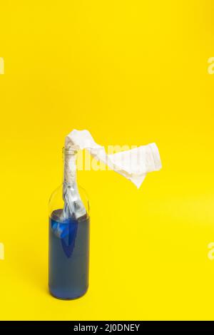 Molotov cocktail bottle full with blue liquid on yellow background. Minimal Ukraine concept. Stock Photo