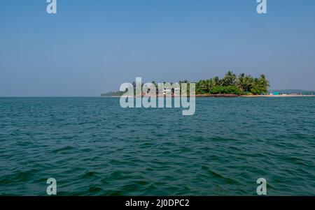 Sindhudurg, INDIA - December 23, 2021 : Beautiful landscape of the Indian ocean with coconut trees, fishing boats and resorts at devbagh beach Stock Photo