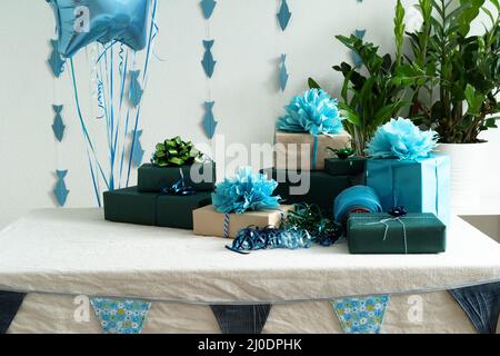 Blue gel balls and gift boxes and flags on the table . The concept of a birthday, wedding or Christmas or holiday. Horizontal photo. Stock Photo