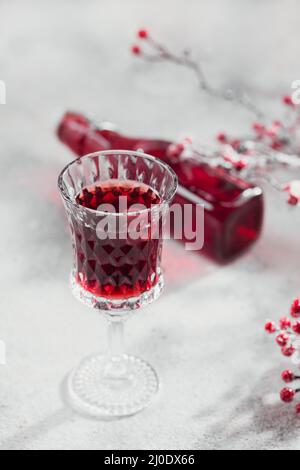 Homemade infused vodka, tincture or liqueur of red cherry on white background. Berry alcoholic drinks concept. Stock Photo