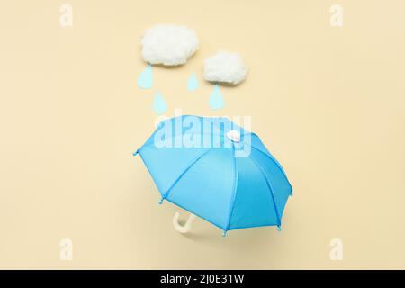 Composition with mini umbrella and cotton clouds on color background Stock Photo