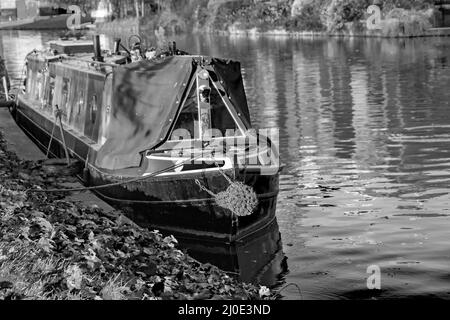 Black and white image of a traditional narrow boat moored on the River Cam in Jesus Green, Cambridge Stock Photo